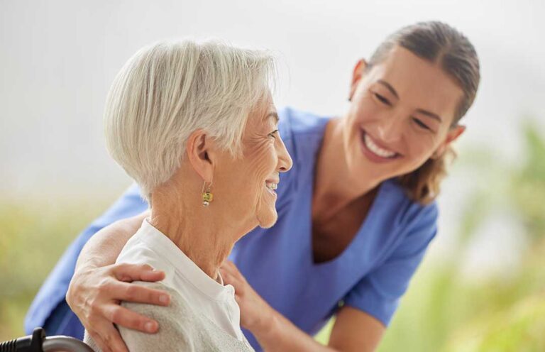 Residents and staff walk through a bright assisted living hallway with handrails, clear pathways, and emergency call buttons.